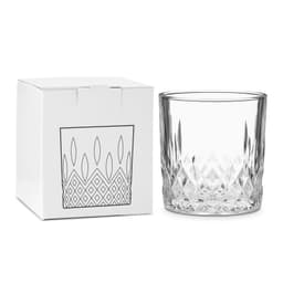 A crystal drink glass sits beside a white box featuring a geometric design. The glass has a clear, faceted finish.