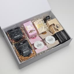 A gift box featuring an assortment of sweets and snacks, including pretzels, marshmallows, Turkish delight, and fudge.