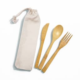 A bamboo cutlery set featuring a fork, knife, and spoon in a calico pouch. The cutlery is light brown, and the pouch is beige.