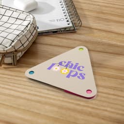 A triangular sticky note pad in beige with colorful corners, featuring the text "chic loops" in purple.