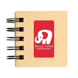 A spiral-bound notebook with a kraft cover featuring a white elephant logo and the text "WILD TUSK DEFENDERS."