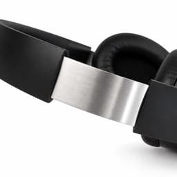 Aero by Nomis headphones in black with a silver band and cushioned ear pads. Features a sleek design and branding.