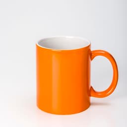 An orange ceramic mug with a glossy finish and a white interior. It has a sturdy handle and a simple design.