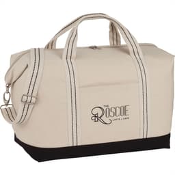 A cream canvas duffel bag with black accents and dual handles, featuring a logo on the side.