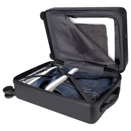 A wheeled black cabin trolley with an open lid, showcasing neatly packed clothes and a towel inside.