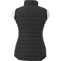 A women's down vest in dark grey, featuring a zip-up design and puffy quilted texture. Includes a logo on the side.
