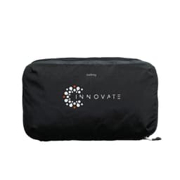 A black packing cube featuring a circular logo, designed for organising travel essentials.