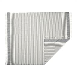 A striped throw blanket in grey and white with fringed edges, featuring an upcycled design.