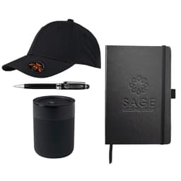 A black cap, black pen, black candle, and black notebook, all featuring branding elements.