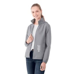 A woman wearing a grey packable rain jacket with a hood, featuring a logo and text on the front.