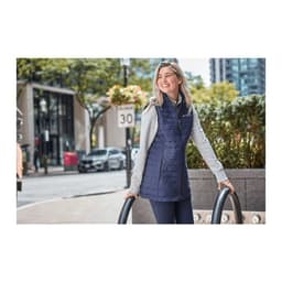 A lightweight, insulated puffer vest in navy, featuring a grey hood, displayed on a woman outdoors.