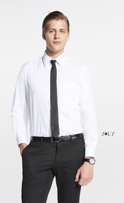 A man in a white shirt and black tie stands confidently, wearing black trousers and a watch. The image features a logo.