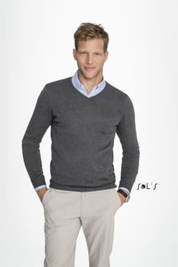 A grey V-neck men's jumper worn over a light blue shirt, modelled by a man with short blonde hair. Features a logo.
