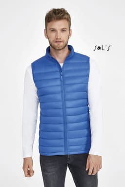 A blue puffer vest featuring a zip front and horizontal stitching, worn by a model. The vest includes a logo.