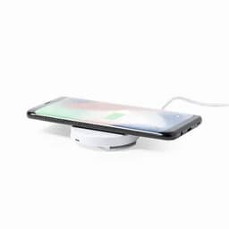 A wireless charger with a compact white base, featuring a smartphone resting on top, showing a charging indicator.