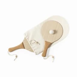 A set of wooden paddle bats with golden handles, a white ball, and a fabric carrying pouch.