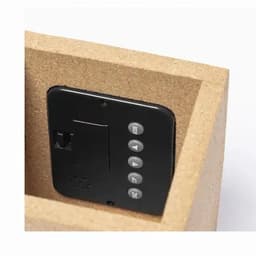 A black device sits inside a light brown box, featuring buttons for various functions.