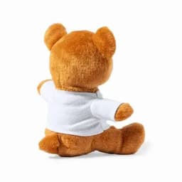 A plush teddy bear with a brown fur coat, wearing a white shirt and sitting on its bottom, facing away.