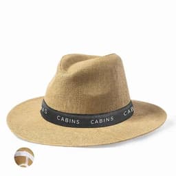 A tan wide-brimmed hat with a black band featuring the word "CABINS." The hat has a textured fabric.