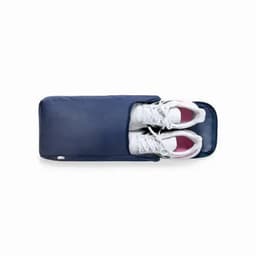 A navy storage bag containing a pair of white sports shoes, featuring a zip closure and a simple design.