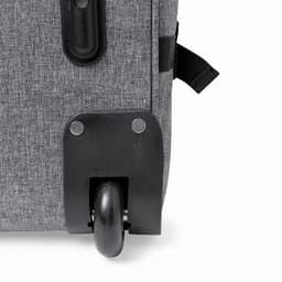 A grey luggage bag featuring a black wheel and mounting plate, designed for mobility.