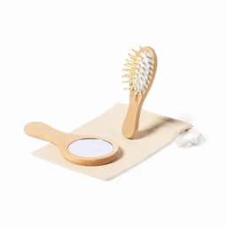 A wooden hairbrush and mirror set displayed on a fabric pouch. The handle and bristles are made of wood.