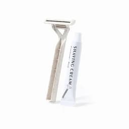 A shaving kit featuring a razor in white and a tube of shaving cream. The kit includes a branding logo.