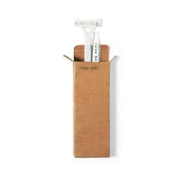 A shaving kit in a brown cardboard box, featuring a razor and two tubes of shaving cream.