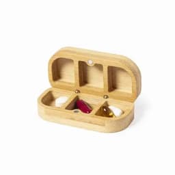 A wooden pill organiser with three compartments, containing two capsules and one tablet. It has a natural finish.