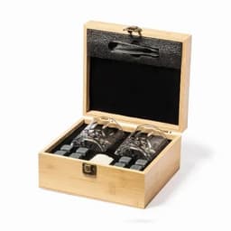 A wooden gift box containing two crystal glasses and several grey cooling stones.