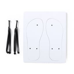 A pair of black sandal straps alongside a white template with outlines of foot shapes and holes for straps.