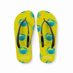 A pair of yellow flip-flops featuring blue crab patterns and black straps. The soles have a branding logo.