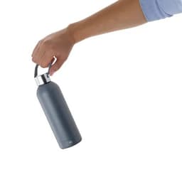 A drink bottle in grey, featuring a silver lid and a carrying strap, held by a hand. It has a logo.