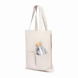 A tote bag in a neutral colour featuring a silver drink bottle in its front pocket. The bag has two handles.