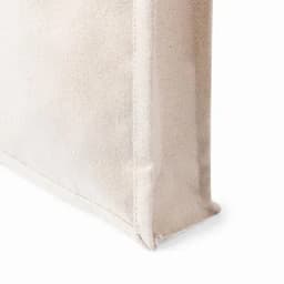A natural, textured bag in a light beige colour with a structured design, featuring visible stitching details.
