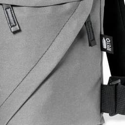 A grey shoulder bag with a textured fabric and adjustable strap, featuring a small brand tag.