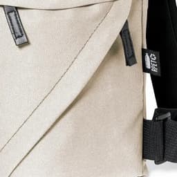 A messenger bag in a light beige colour with a black strap and branding tags. The material appears durable and textured.