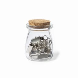 A glass jar with a cork lid filled with silver binder clips. The jar has a rounded shape.
