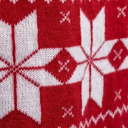 A close-up of a red and white knitted pattern featuring snowflakes and geometric designs.