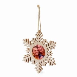 A wooden snowflake ornament featuring a circular photo frame in the centre, with a string for hanging.