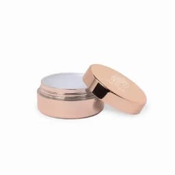 A cream container in a rose gold finish with a white inner lining and a fitted lid. It features a logo on top.