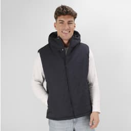 A man wearing a dark navy sleeveless puffer vest with a hood, paired with a light-coloured long-sleeve shirt.