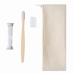 A toothbrush, hourglass timer, toothpaste tablet, and a beige zippered pouch are arranged together.