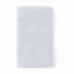 A fluffy light blue towel with a textured surface, featuring a logo at the corner.