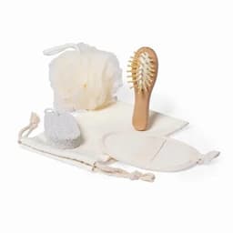 A bath set featuring a loofah, a wooden hairbrush, a pumice stone, and cotton storage bags in neutral tones.