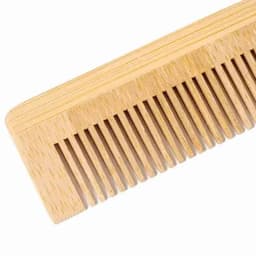 A wooden comb with a light brown finish, featuring fine and wide teeth. The comb has a distinctive, smooth texture.
