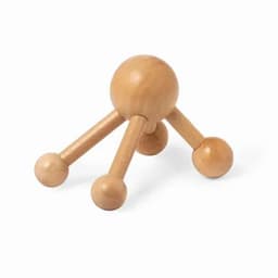 A wooden massage tool with a spherical body and three legs, each ending in a smaller spherical shape.