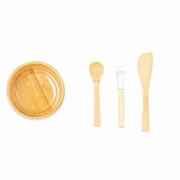 A bamboo dish set featuring a round bowl, a spoon, a spatula, and a spreading knife. All items are natural bamboo.