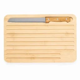 A bamboo cutting board with grooves and a serrated knife with a wooden handle placed on top.