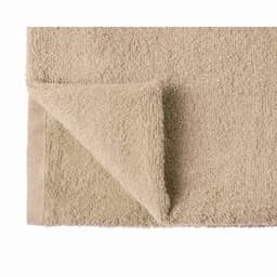 A beige towel with a folded corner, featuring a textured, plush surface. It has a simple, clean design.